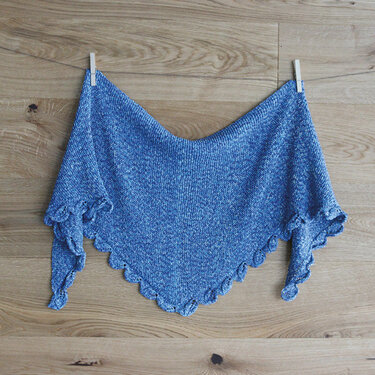 Gestricktes blaues Dreieckstuch mit Muschelkante an Wäscheklammern