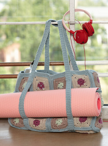 Gehäkelte Granny-Square-Tasche mit rosa Yogamatte und roten Kopfhörern