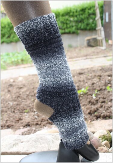 Gestrickte graue Beinstulpen mit offener Ferse am Bein