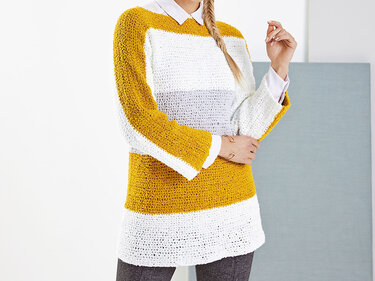 Frau trägt einen gestreiften Strickpullover in Senfgelb, Weiß und Grau über einem weißen Hemd.