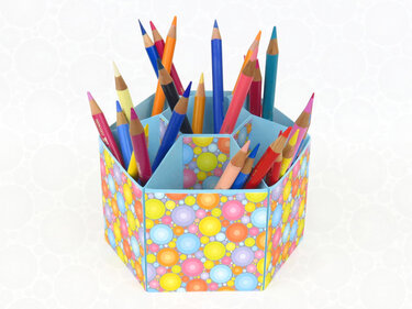 Sechseckiger Papier-Stiftehalter mit buntem Punktmuster und Buntstiften