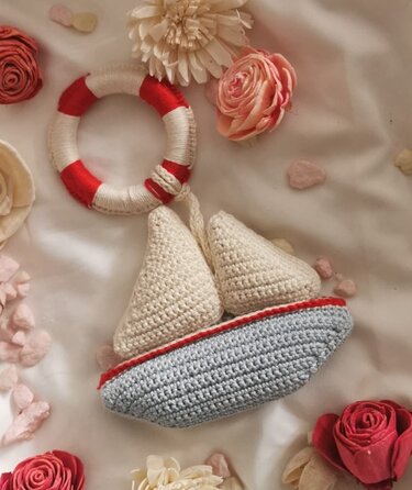 Gehäkelte Segelboot-Rassel mit rundem Greifring in Rot, Creme und Grau