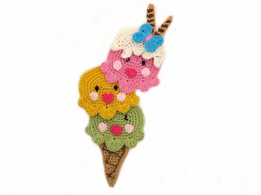 Whimsical crochet ice cream appliqué with smiling faces, blue bow and cone