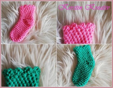 Zwei gehäkelte Babysocken (Pink und Türkis) mit Rüschenrand auf hellem Kunstfell.