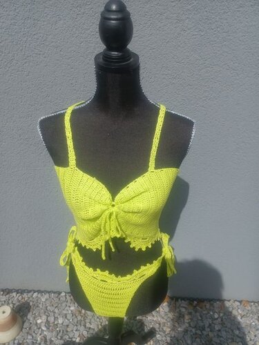 Neongelbes gehäkeltes Bikini-Set auf schwarzer Schneiderpuppe