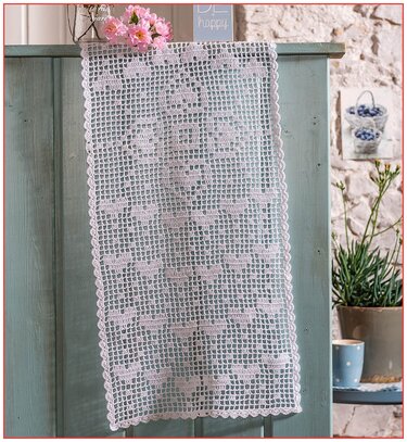 Weißer gehäkelter Tischläufer mit Herz-Filetmuster an hellblauer Kommode