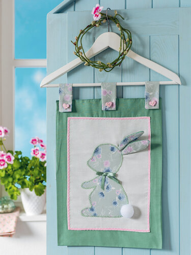 DIY-Nähprojekt: grüner Wandbehang mit appliziertem Häschen, drei Schlaufen und weißem Bommel