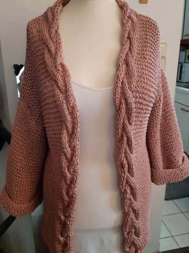 Hellrosa Damen-Strickjacke mit Zopfmuster an der Vorderkante und hochgekrempelten Ärmeln auf einer Schaufensterpuppe