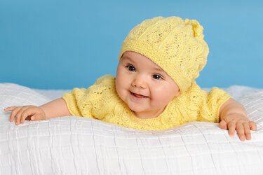 Gelber Overall und Mütze mit Lochmuster