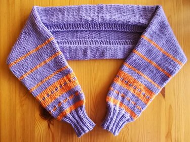 Gestrickter Kinderbolero in Violett und Orange mit Streifen und Lochmuster, auf Holztisch präsentiert