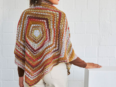 Rückansicht: gehäkeltes Poncho-Tuch mit mehrfarbigem Quadratmuster in herbstlichen Farben