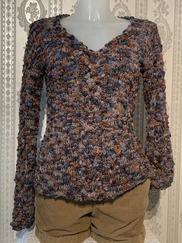 Gestrickter Damenpullover mit V-Ausschnitt in melierten Blau- und Brauntönen auf Schaufensterpuppe