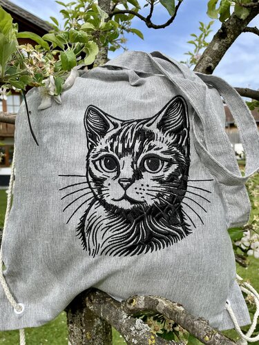 Grauer Beutel mit gesticktem, detailliertem Katzenkopf als Motiv.