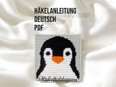 Quadratisches gehäkeltes Pixelmotiv eines Pinguins mit schwarzem Kopf, weißem Bauch und orangefarbenem Schnabel