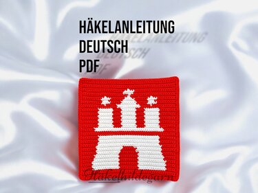 Quadratisches gehäkeltes Pixelmuster in Rot mit weißem Tormotiv und dem Schriftzug 'HÄKELANLEITUNG DEUTSCH PDF'