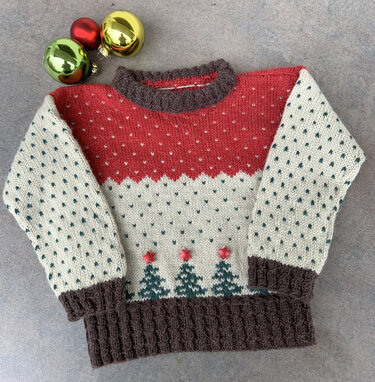 Gestrickter Kinderpullover in Rot, Creme und Braun mit Tannenbordüre und roten Sternknöpfen