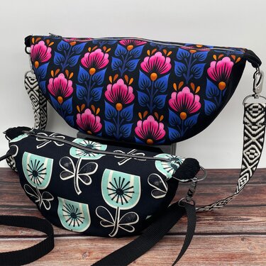 Zwei halbmondförmige Taschen mit Blumenmustern, Reißverschluss und abnehmbaren Tragegurten