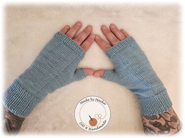 Paar hellblauer, gestrickter fingerloser Armstulpen an Händen auf hellem Hintergrund