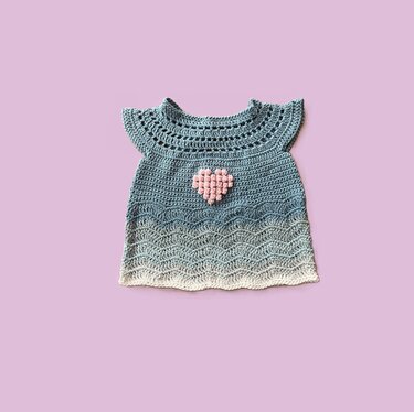 Häkel-Tunika für Baby mit Muschel- und Wellenmuster und rosafarbenem Bobbelherz