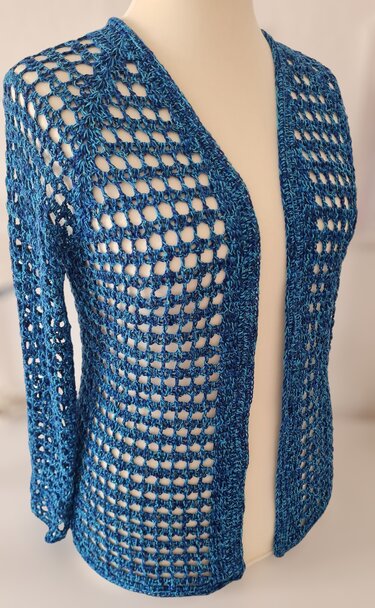 Gehäkelte blaue Damenjacke mit offenem Netzmuster auf einer Schneiderpuppe