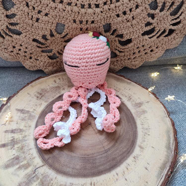 Gehäkelter rosa Oktopus-Amigurumi mit spiralförmigen Tentakeln und gestickten Augen