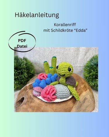 Gehäkelte Amigurumi-Schildkröte auf kleinem Korallenriff mit bunten Korallen auf Holzuntergrund