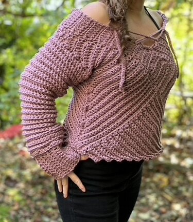 Dusty rose crochet pullover showing diagonal rib stitch, scalloped hem and lace ties
