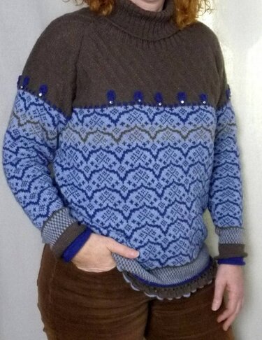 Raglanpullover maschinengestrickt mit Jacquardmuster, Zierborte und gewelltem Saum