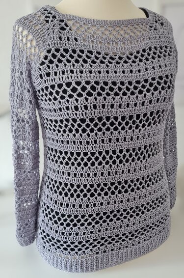 Hellgrauer gehäkelter Damenpullover mit Ajourmuster auf Schaufensterpuppe