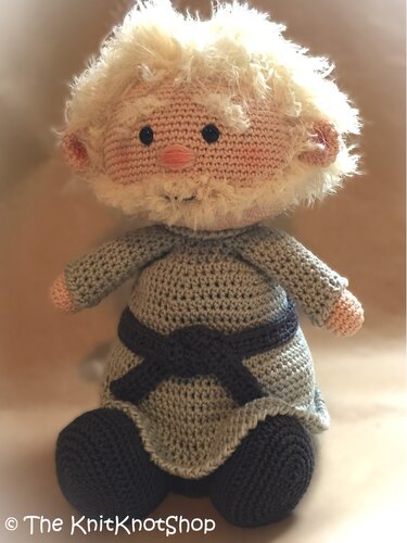 Seated crocheted gnome with gray outfit and wide round base
