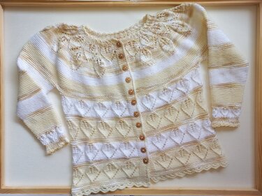 Gestrickte Cardigan für Baby in Weiß und Beige mit Lochmuster und Holzknöpfen