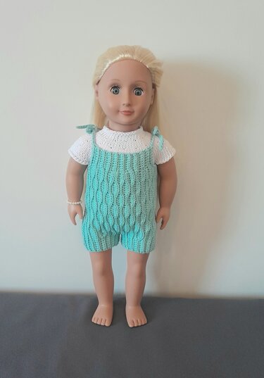 Puppe mit türkisfarbener Latzshorts mit Strukturmuster und weißem Kurzarmshirt