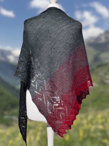 Gestricktes Dreieckstuch mit Farbverlauf von Grau zu Rot und dekorativer Lochkante auf einer Schaufensterpuppe drapiert