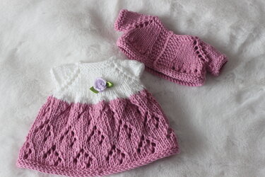 Pink lace-pattern knitted doll dress with white short-sleeve yoke and matching pink cardigan