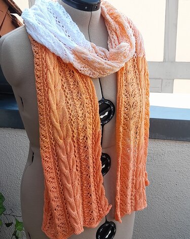 Gestrickter Schal in Weiß-Orange mit Zopfmuster und Ajourmuster auf Schneiderpuppe