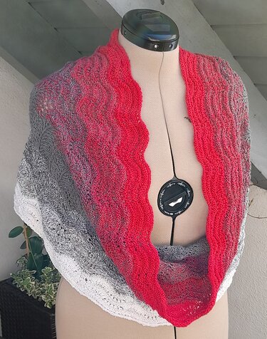 Gestrickter Loop-Schal in Rot, Grau und Weiß mit Wellenmuster auf Schneiderpuppe drapiert