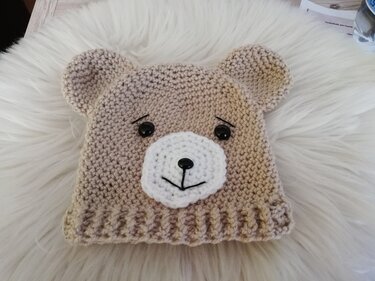 Häkelmuster-Idee einer Babymütze im Bärenlook mit Ohren, weißer Schnauze und Knopfaugen