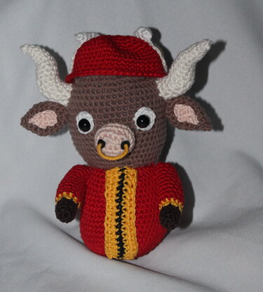 Gehäkeltes Stier-Amigurumi mit roter Jacke, Mütze und Nasenring
