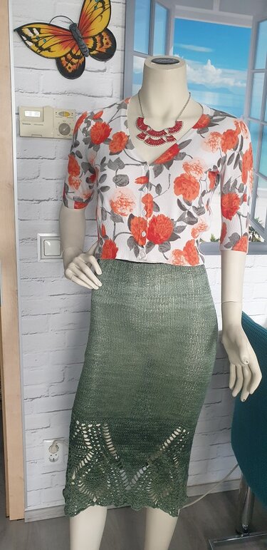 Mannequin mit olivgrünem gestrickten Bleistiftrock mit Spitzensaum und geblümtem Oberteil
