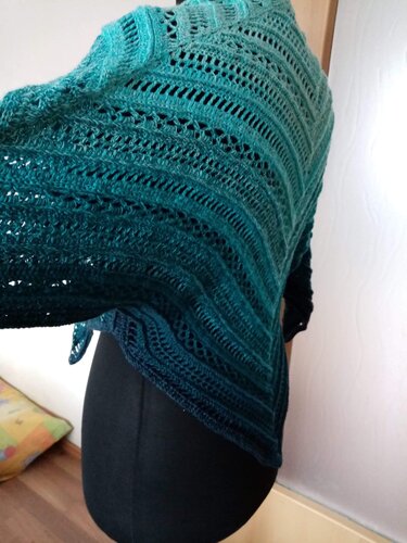 Detailaufnahme eines gehäkelten Dreieckstuchs mit Lochreihen und Farbverlauf in Blau- und Türkistönen auf Schneiderpuppe