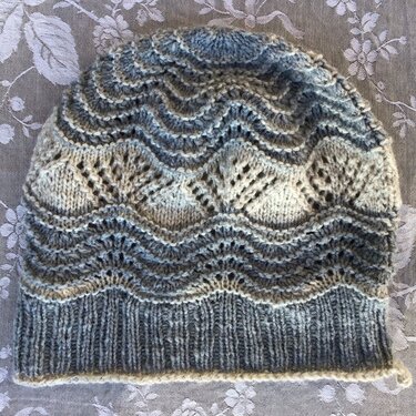 Gestrickte Damenmütze Grau-Beige mit Rippenbund und wellenförmigem Lacemuster