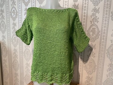 Grüner Damen-Strickpullover auf Mannequin, U-Boot-Ausschnitt, kurze Ärmel, gelochter Saum