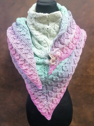 Gehäkeltes Dreieckstuch in Pastellfarben (Rosa, Lila, Mint, Creme) mit strukturiertem Muster auf einer Schaufensterpuppe.