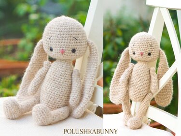 Beige crocheted amigurumi bunny with long floppy ears and a pink nose on a white chair