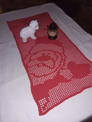 Rechteckiger roter Häkel-Läufer mit Rosenmuster, arrangiert mit einer kleinen Laterne und einer weißen Deko-Bärenfigur