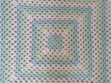 Gehäkelte Babydecke im Granny‑Square‑Muster in Hellblau, Mintgrün und Weiß, Detailansicht