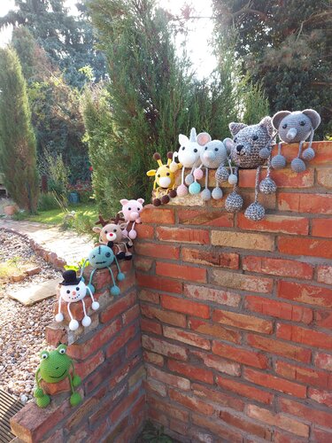 Verschiedene gehäkelte Amigurumi-Muster an einer Ziegelmauer zum Vergleich von Formen und Farben