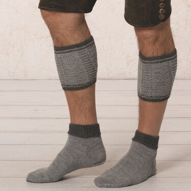 Beine eines Mannes mit grauen Loferl und kurzen Socken, Detailaufnahme
