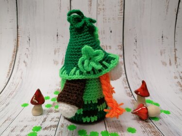 Grüner gehäkelter Wichtel mit Kleeblatt, Zipfelhut und orangefarbenem Zopf