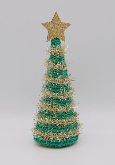 Kleiner gehäkelter Weihnachtsbaum mit goldener Lametta und Stern